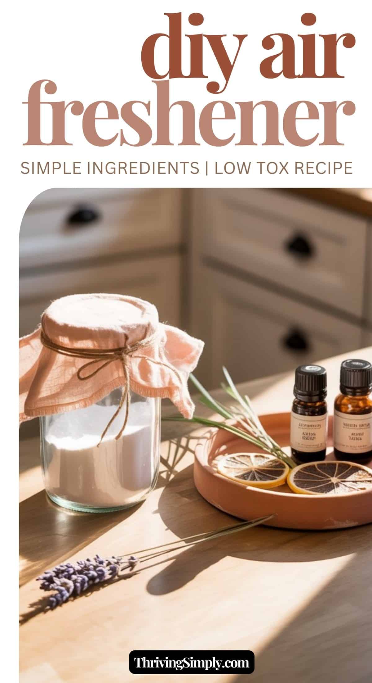 A jar with a fabric cover, dried citrus slices, essential oil bottles, and lavender sit on a sunlit kitchen counter. Text reads, DIY air freshener: Simple ingredients | Low tox recipe for a natural home freshener.
