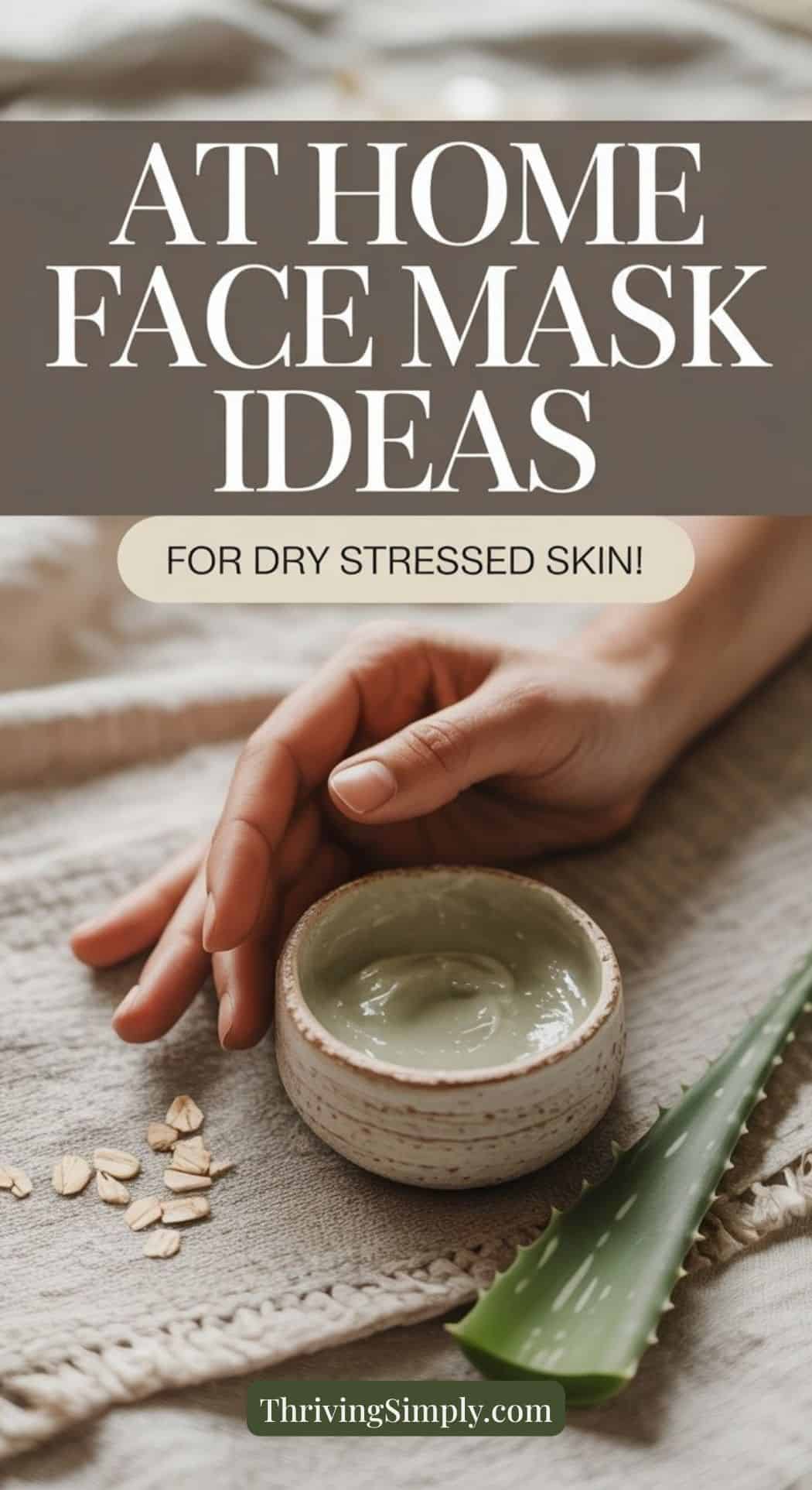 A person’s hand rests on a textured fabric beside a small bowl of green DIY face mask, oat flakes, and an aloe vera leaf. Text reads: “At Home Face Mask Ideas for Tired Skin! ThrivingSimply.com.”.